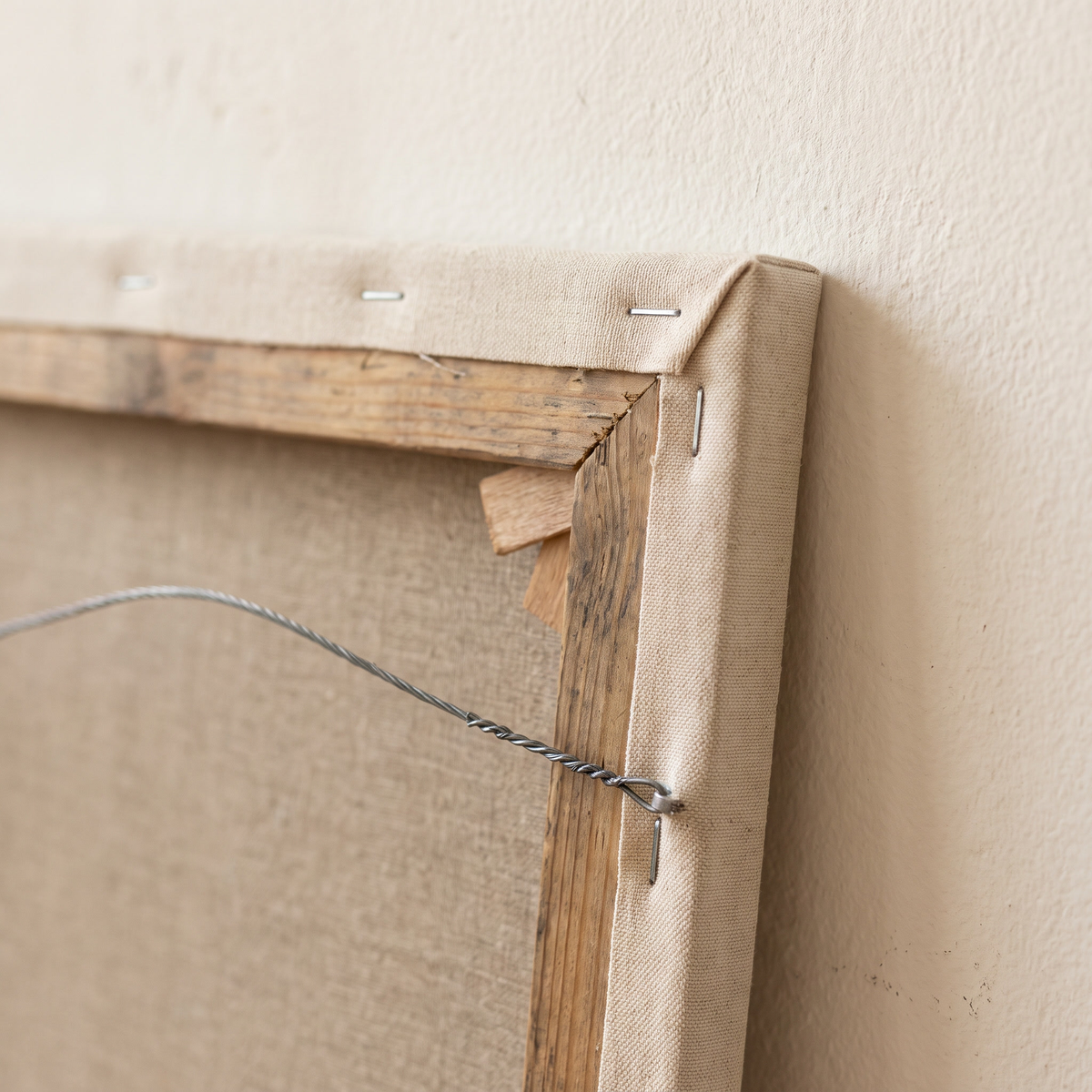 The back of the gallery-wrapped canvas: stretcher bars, folded corners and hanging wire